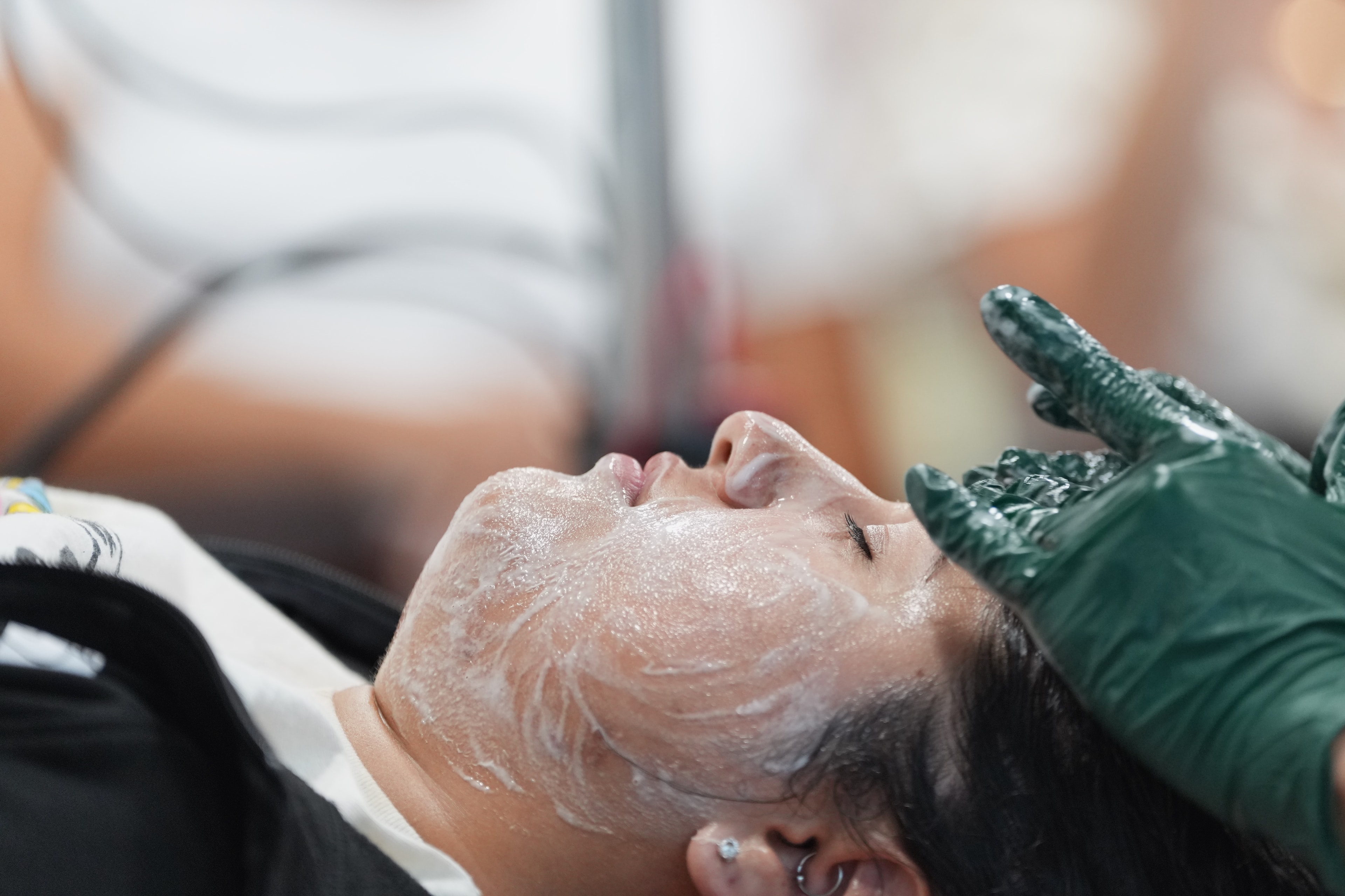 Esthetician performing an advanced facial treatment during a Sugar Con education session